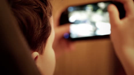 un adolescente está jugando en su consola de juegos portátil