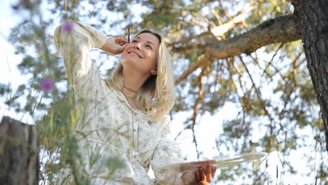 blonde woman artist painting outdoors in nature