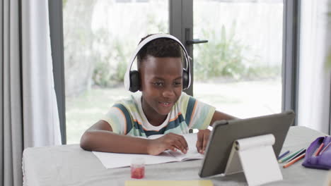 african american boy studies at home using a tablet