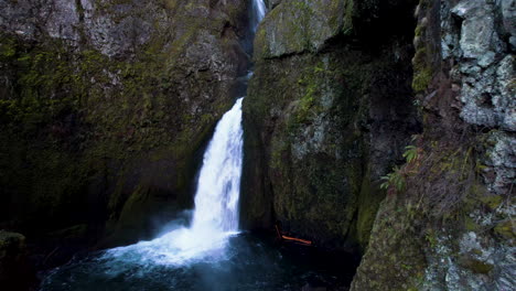 a drone moving around a cliffside to reveal a water fall