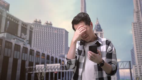 smiling asian man freelancer using smartphone and drinking coffee while standing in front of buildings working in a city