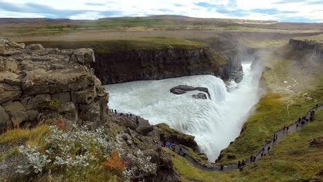 gullfoss waterfall in cloudy weather, dramatic clouds, many tourists are visiting, in summer day