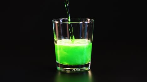 green drink being poured into a glass