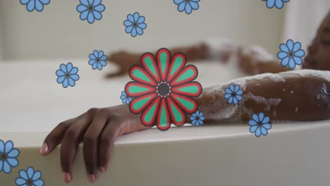 animación de flores azules sobre una feliz mujer afroamericana relajándose en el baño en casa