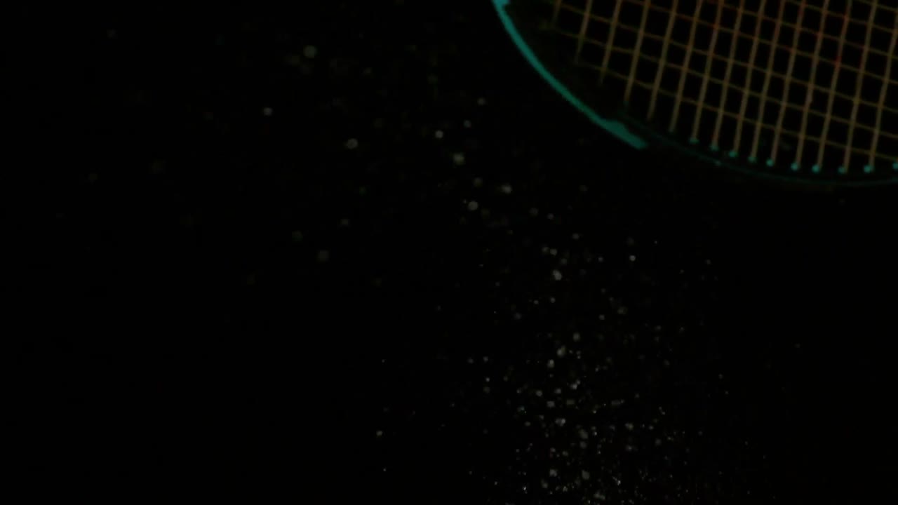 테니스 라켓이 검은 바탕에 공을 때리고 있다