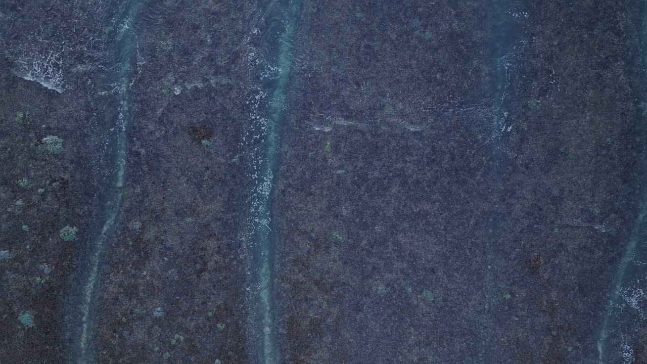 인도네시아 루와투 발리 (uluwatu bali) 의 빙긴 해변의 저류 산호초 위에서 낮은 고도에서 내려다보는 드론 촬영