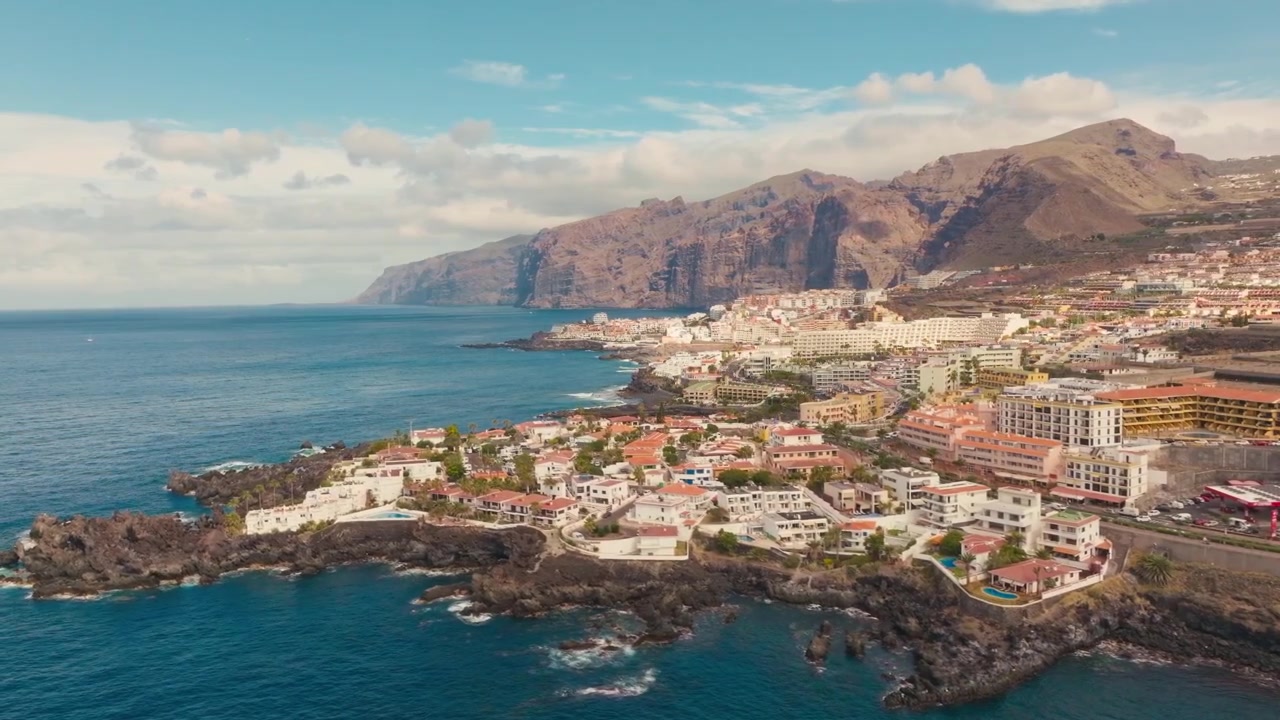 Vistas cinematográficas con dron de las aguas cristalinas, costas volcánicas, playas doradas y el vibrante ambiente veraniego de la isla de Los Gigantes en Tenerife, capturadas desde el aire.