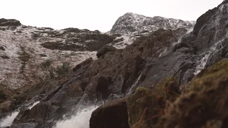 Un-Río-Que-Fluye-Debajo-De-Una-Montaña-Cubierta-De-Nieve