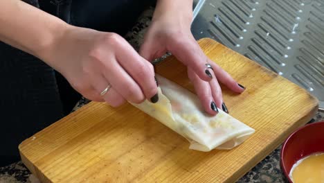 close shot of the hands of a woman doing a spring roll