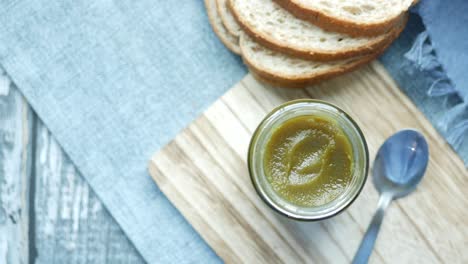 Kaya-spread-in-a-container-and-bread-on-table-,