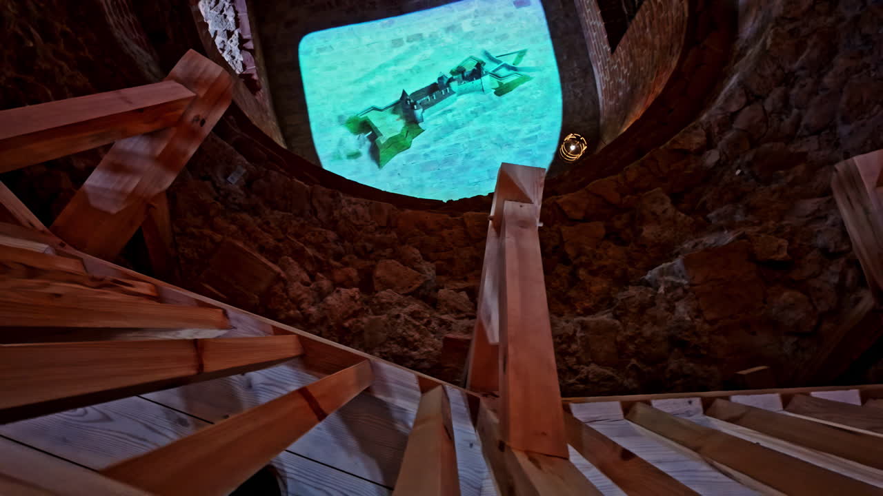 바우스카 성 라트비아 내부의 주조 철 대포 led 조명 디스플레이를 보기 위해 내려다보고 있습니다.