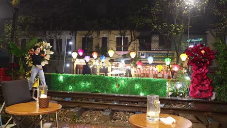 woman walking near decorated train tracks at night