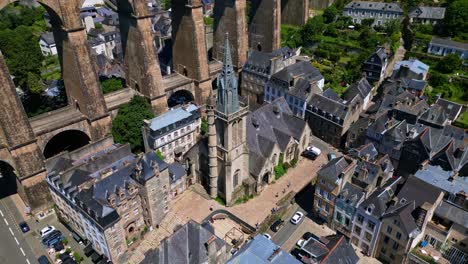saint melaine church, nestled below towering arches of magnificent morlaix viaduct in brittany, france. aerial approach