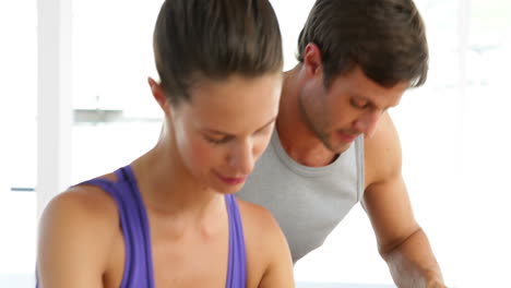 pareja en forma haciendo ejercicio en bicicletas en un estudio de fitness