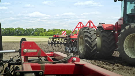 Agricultural-tractor-with-plowing-trailer-working-on-field.-Farming-agriculture