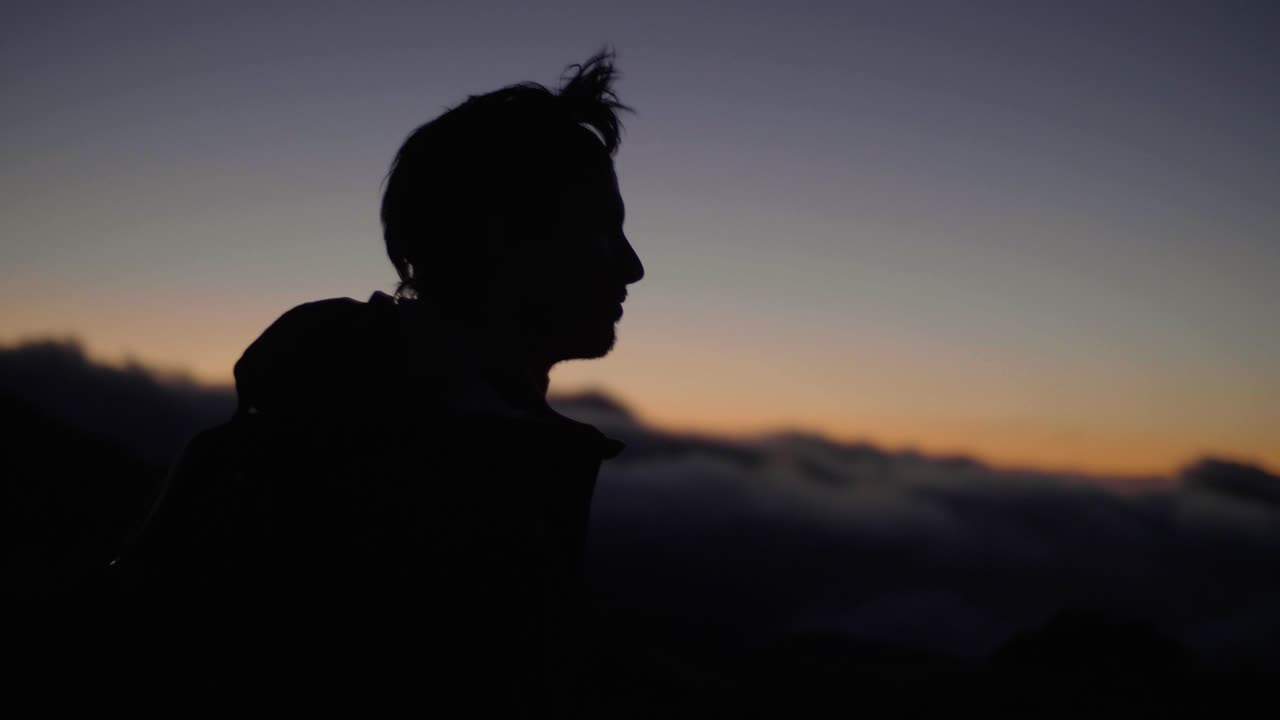 Isola di Madeira, Portogallo - Silhouette di un uomo che cammina da solo all'aperto in un tramonto fresco e ventoso - Primo piano.