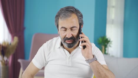 un hombre nervioso de mediana edad al teléfono.
