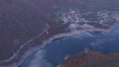 Weitwinkelaufnahme-Des-Piva-See-Canyons-In-Montenegro-Mit-Niedrigen-Wolken-Bei-Sonnenaufgang,-Luftaufnahme