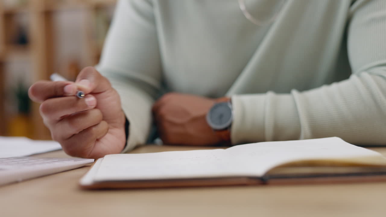 Man, hands and writing in book on table