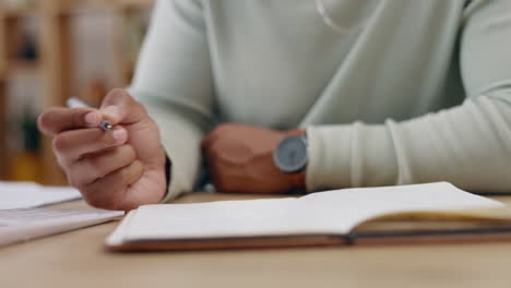 Man,-hands-and-writing-in-book-on-table