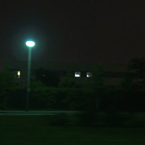 a car travels along a street at night in century city los angeles as seen through the side window 1