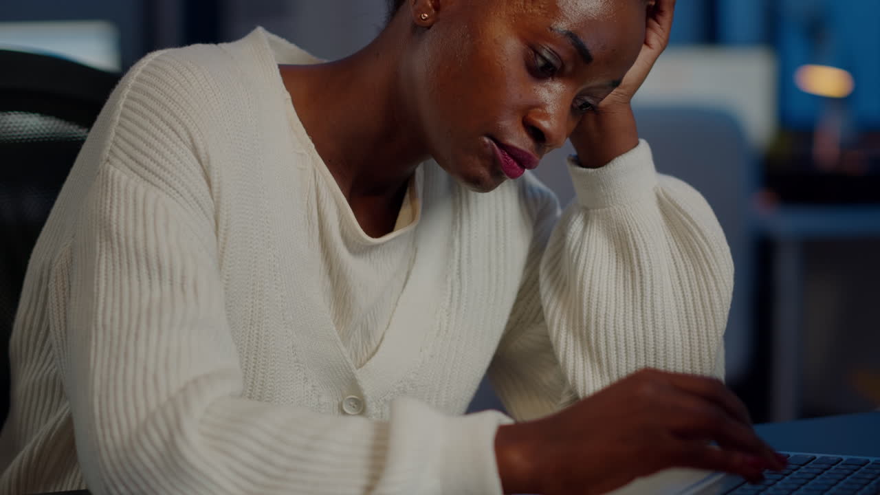 Tired black woman almost napping on chair working on laptop in start up office