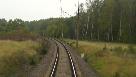 mirando las vías del tren mientras va en un tren