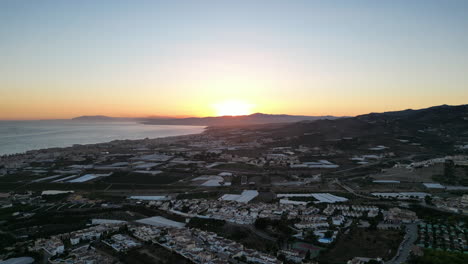 Drone-looking-at-sunset-while-rising-up-and-then-tracking-sideways