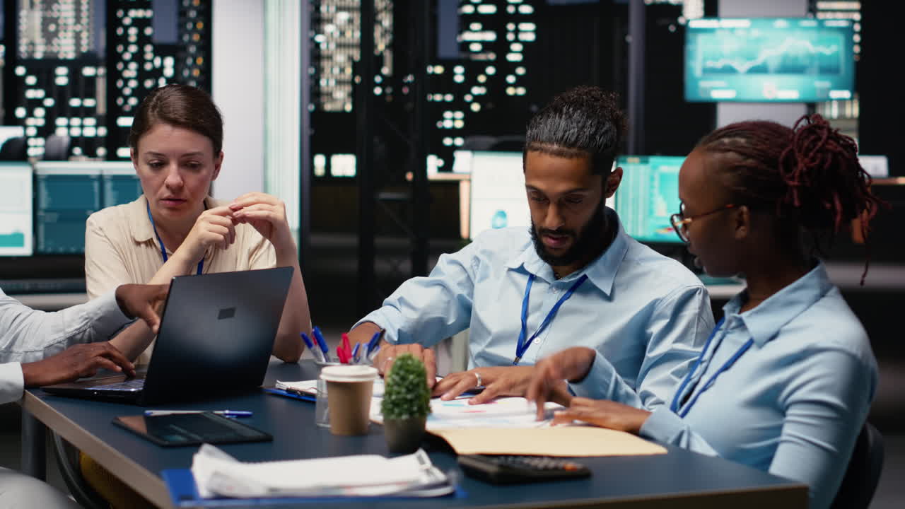 Multiethnic office coworkers reading emails on laptop in boardroom