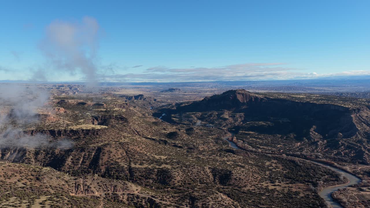 Uma dramática perspectiva de drone revela um vasto cânion desértico e um rio sinuoso pela manhã. Este plano 4K destaca as mesas rochosas e o planalto desértico de altitude de uma paisagem remota do Sudoeste