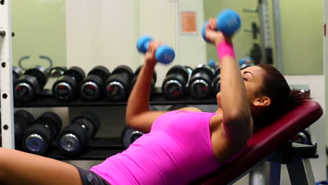 Sporty-young-woman-lifting-dumbbells-