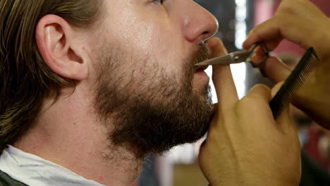 man getting his beard trimmed with scissors 4k