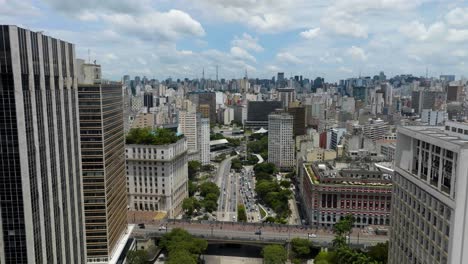 aerial overview of traffic on a highway in middle of buildings in sunny sao paulo, brazil