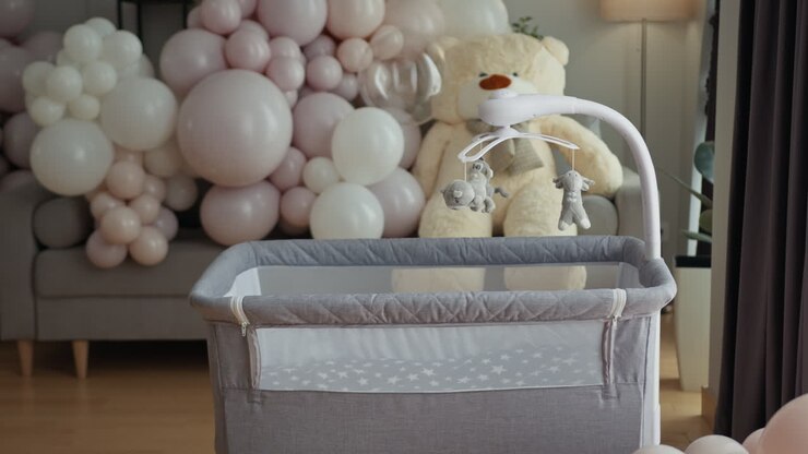 Nursery setup featuring crib large teddy bear balloon decorations creating festive atmosphere for