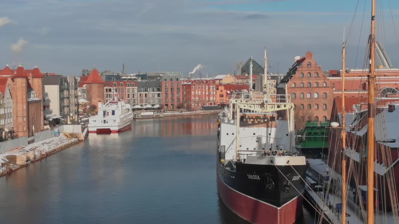 Vista del porto di Danzica con navi ed edifici lungo l'acqua.
