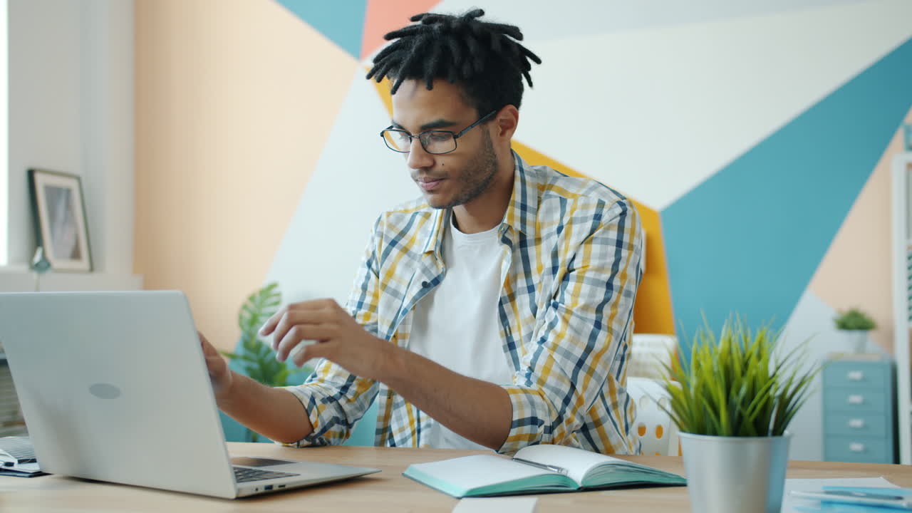 Young Man Working on Laptop in Modern Home Office