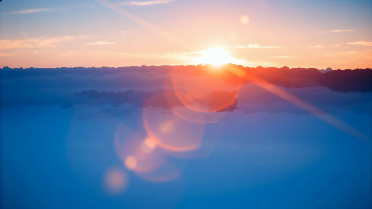 Revealing sun rising and causing hex flares above low horizon coast, marking sunrise with starburst