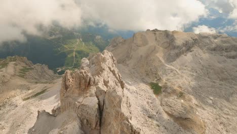 Drone-descends-Lagazuoi-mountain,-Italian-Dolomites,-through-clouds,-then-skims-the-ridge