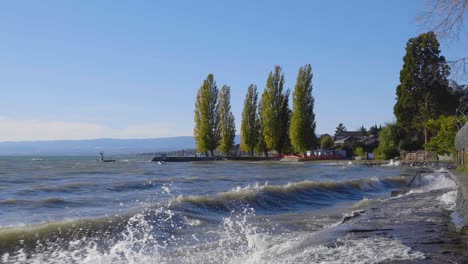 pathway along the shore of lake léman splashed by the waves on a windy day