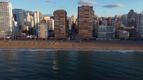aerial side view of several old apartment buildings on the beachfront of benidorm, alicante, spain
