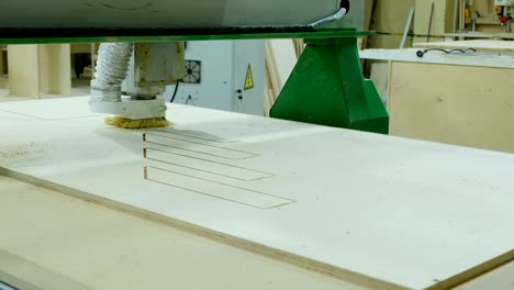 máquina moderna de carpintería en acción. corta piezas rizadas de hoja de contrachapado. producción de muebles de madera