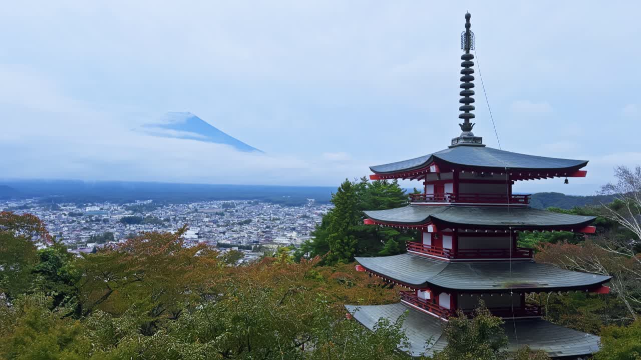 Static establishing of Chureito Pagoda with misty mountain backdrop, serene landscape in Japan
