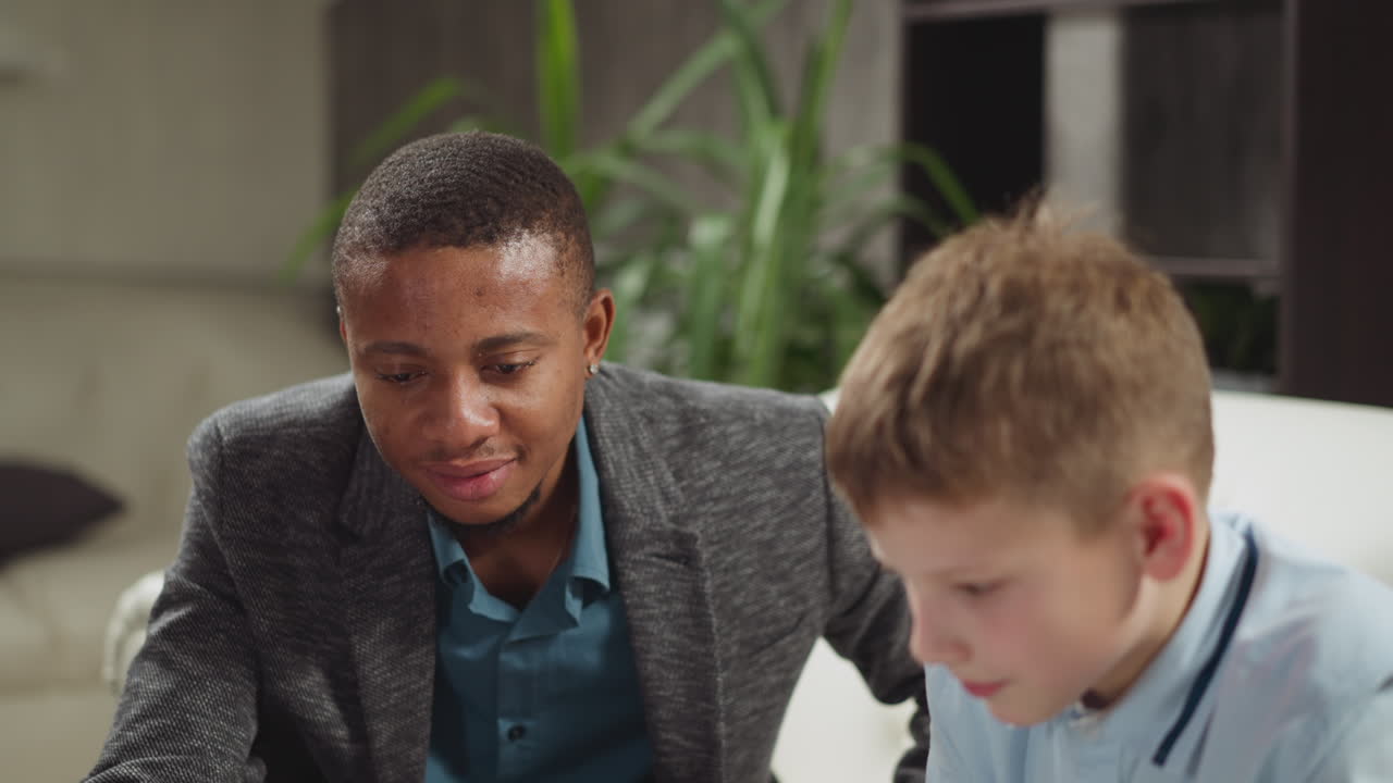 tutor negro apoya a un escolar en una lección privada de inglés