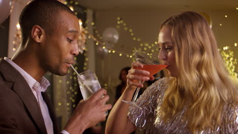 couple make toast as they celebrate at party together