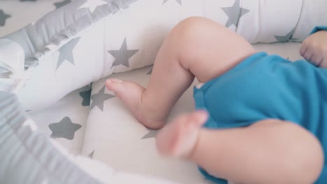 small boy in azure rests kicking legs in cocoon closeup