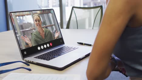 Mujer-Afroamericana-Usando-Una-Computadora-Portátil-Para-Videollamadas,-Con-Un-Colega-De-Negocios-En-La-Pantalla