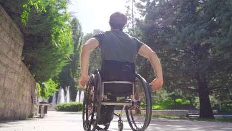 disabled man in wheelchair moves on the road.