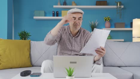 un viejo hombre de negocios reflexivo examinando papeles en casa.