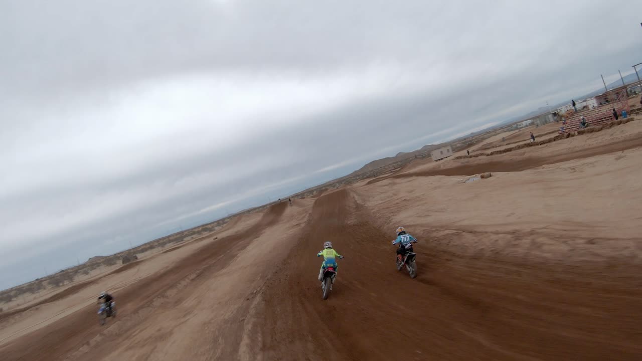 오토바이가 모하비 사막에서 점프를 하며 트랙을 질주하면서 따라가는 고속 드론