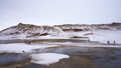 tourists visiting myvatn geothermal area with rising steam on iceland,europe - wide shot